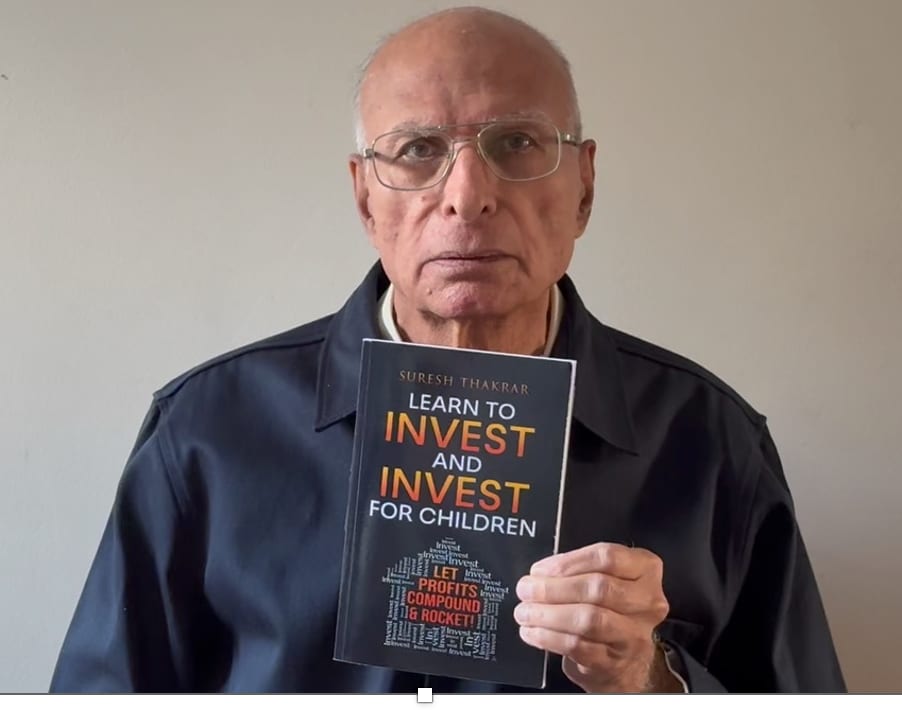 Suresh Thakrar holding a copy of Learn to Invest and Invest for Children